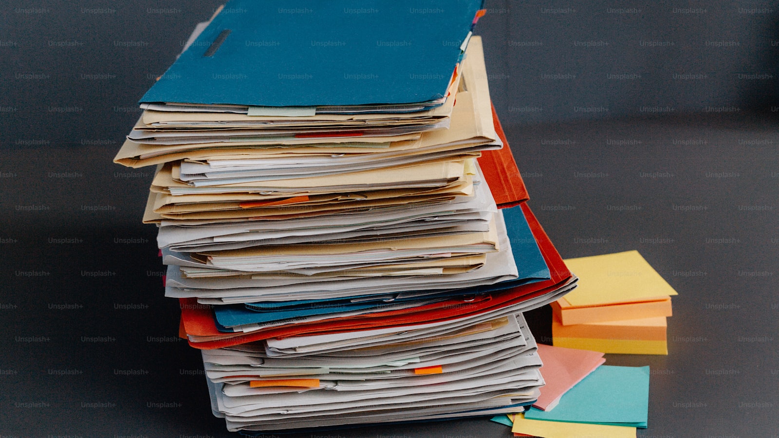 A stack of folders and papers on a desk