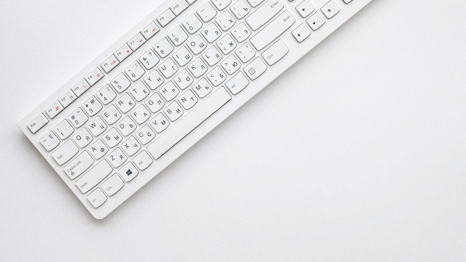 A compact white keyboard on a clean desk