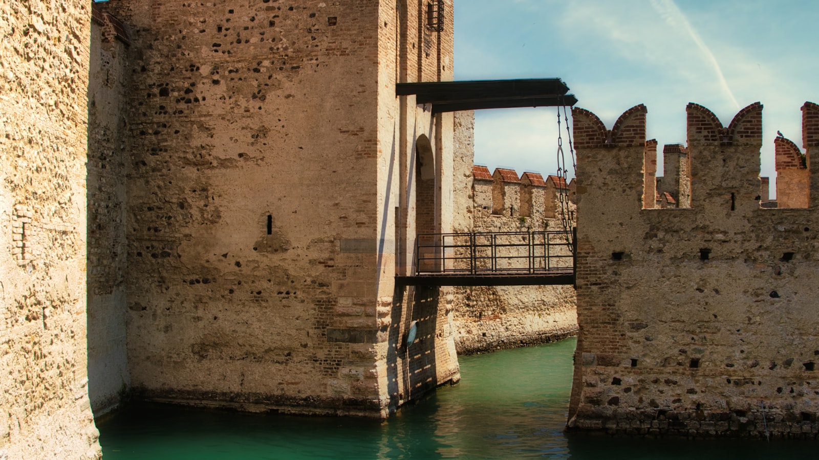 A medieval castle with a drawbridge crossing a wide moat